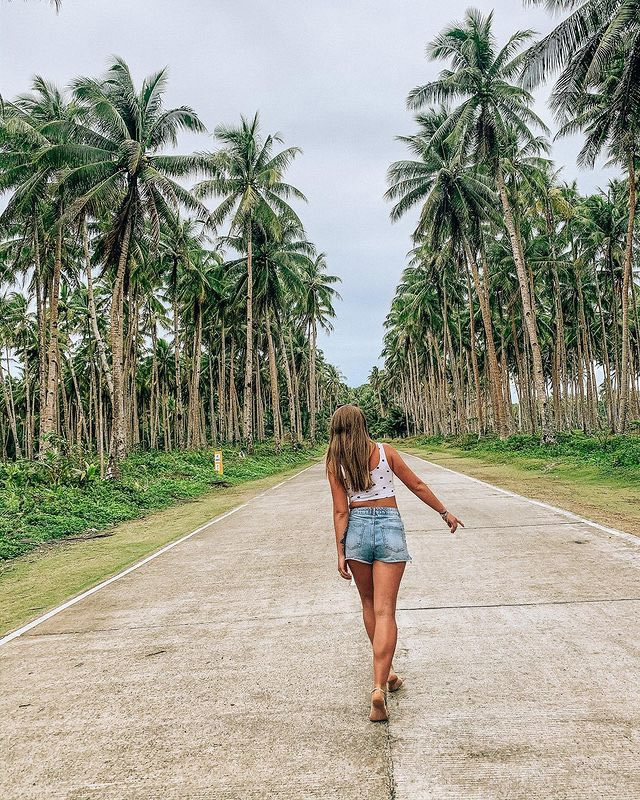 Woman walking in the iconic coconut road in Siargao Island Philippines