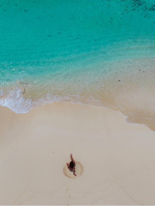 Woman comfortably sitting at Daku Island beach.